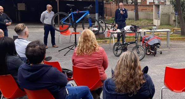 El equipo de instructores junto al público interno que participó del taller de reparación de bicicletas en el estacionamiento de Casa Central, detrás del espacio de guardado exclusivo de bicicletas y motos de La Caja. 