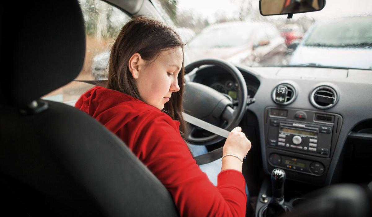 Mujer se pone el cinturón de seguridad en un auto