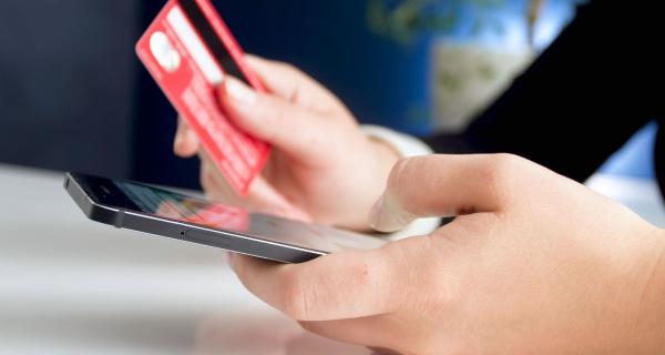 Persona comprando por internet con una tarjeta bancaria