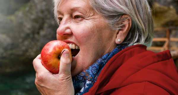 Señora mayor comiendo manzana
