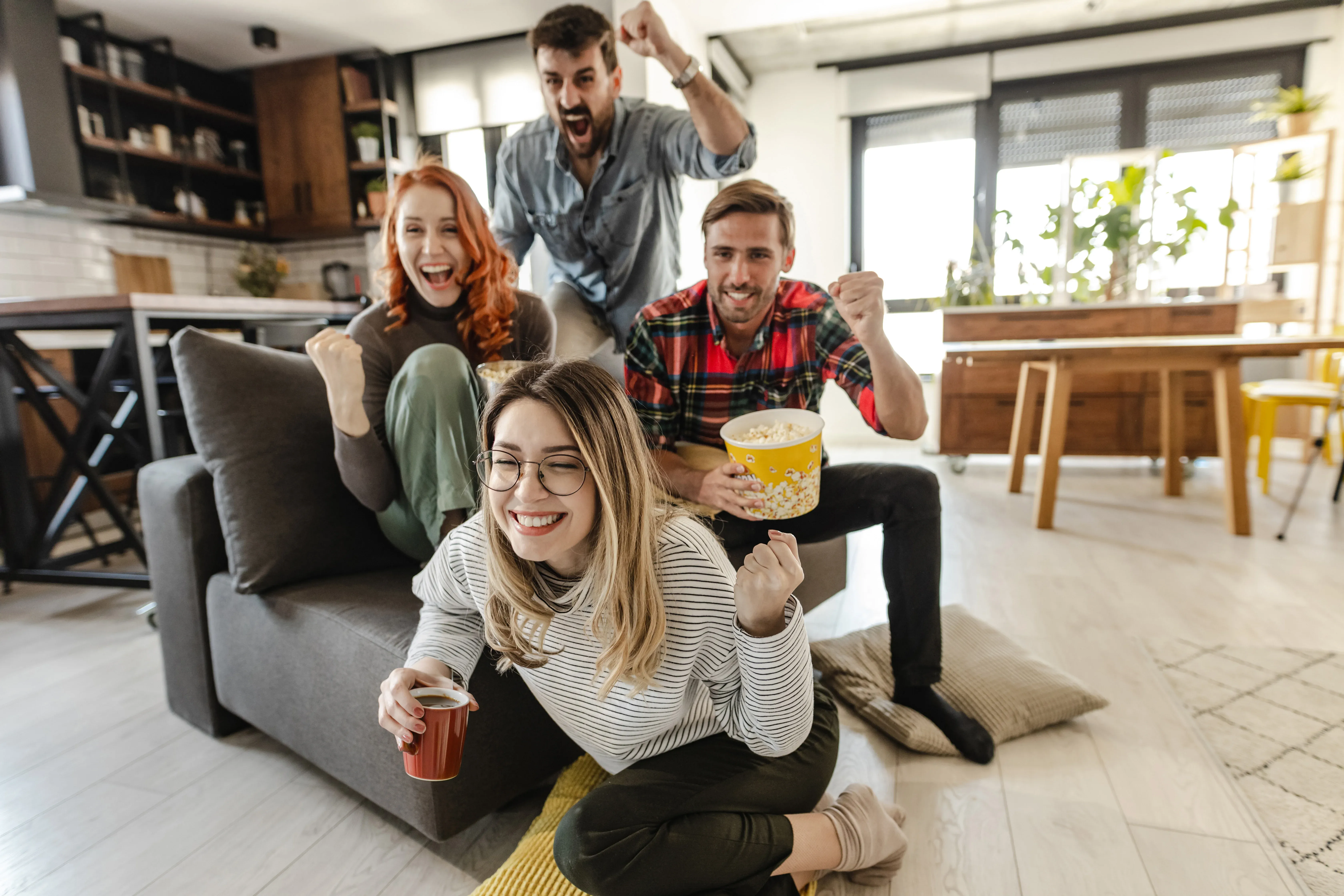 Amigos reunidos en casa viendo un partido de fútbol por TV